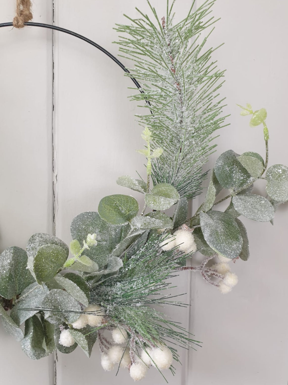 Green leaf and white berry on metal wreath
